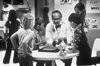 Dr. C. Henry Kempe, surrounded by young children. Kempe is widely credited with introducing the term "battered child" and sparking recognition of physical child abuse. (Kempe Center)